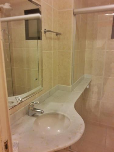 a bathroom with a sink and a glass shower at Canto do Atlântico Hotel in Guarujá