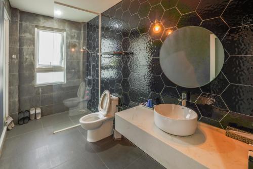 a bathroom with a sink and a toilet and a mirror at AP HOME - Lakeside in Ấp Ðinh An (1)