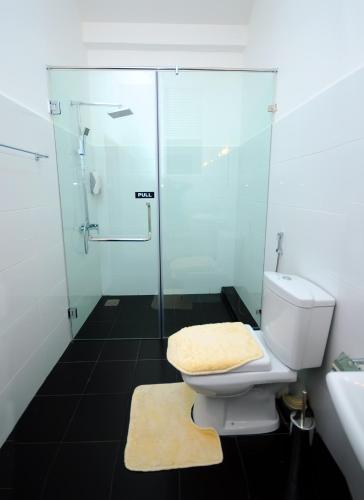 a bathroom with a toilet and a glass shower at City Stay in Galle