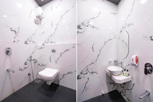 a white bathroom with a toilet and a sink at FabHotel Elvis International in Mumbai