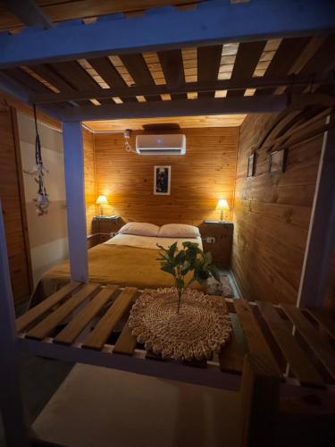 a bedroom with a bed and a table with a plant on it at Cabañas las fulanas in Villa Giardino
