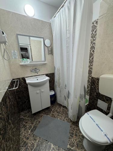 a bathroom with a toilet and a sink and a mirror at Hotel Iulia Resort in Venus