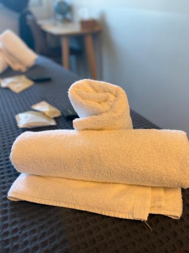 a stack of towels sitting on top of a bed at The Athenian Pearl in Athens
