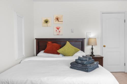 a white bed with colorful pillows on top of it at Home Base Quiet Queen Rooms in Richmond