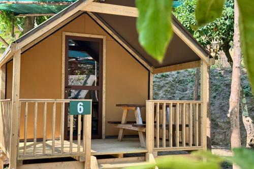 a wooden play house with a porch and a bench at Hostel & Glamping Santa Fortunata in Sorrento