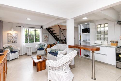 a kitchen with wicker chairs and a table in a room at Mermaid Cove - Blue Bay in Blue Bay