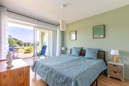 a bedroom with a bed and a large window at Green Flat - Appt proche des Sables dOlonnes in LʼAiguillon-sur-Vie
