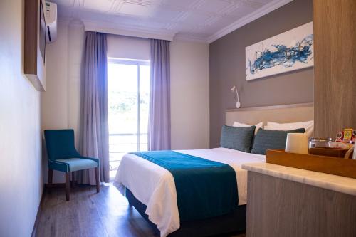 a hotel room with a bed and a window at Regal Inn Ballito in Ballito