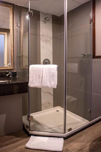 a shower with a glass door in a bathroom at Regal Inn Ballito in Ballito
