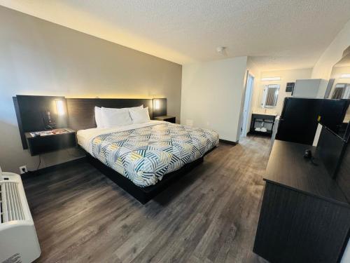 a hotel room with a bed and wooden floors at Motel 6-Southgate, MI - Detroit in Southgate
