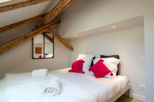 a bedroom with a white bed with red pillows at Cabane Malou - Avec jardin et à 200 m des pistes in La Salle-les-Alpes