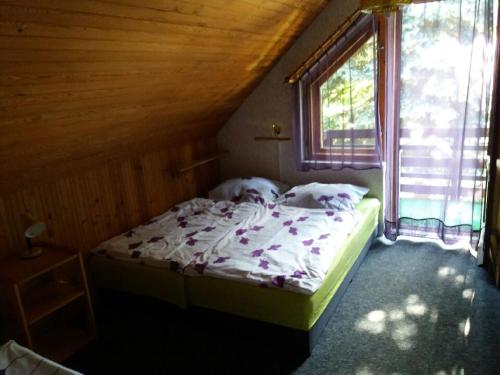 a small bed in a room with a window at CHALET Dom z basenem in Lutol Mokry