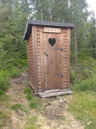 a wooden out house with a heart on the door at JVT Cabins in Kiruna