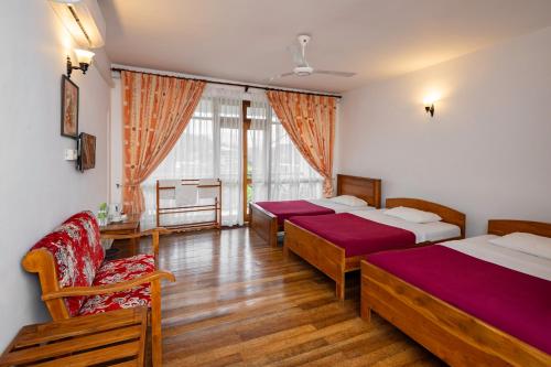 a bedroom with three beds and a couch and a chair at Alta Vista in Ella