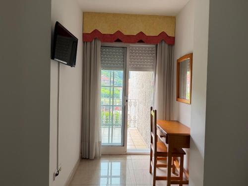 a room with a desk and a sliding glass door at Casa Rodiño in Meaño