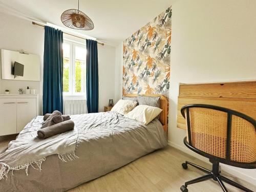 a bedroom with a bed and a chair in it at L'Échappée Croisienne in Croix