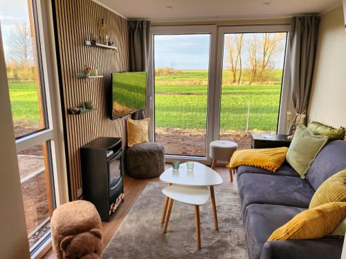 a living room with a couch and a tv at Tiny Haus Schwalbe in Groß Kordshagen