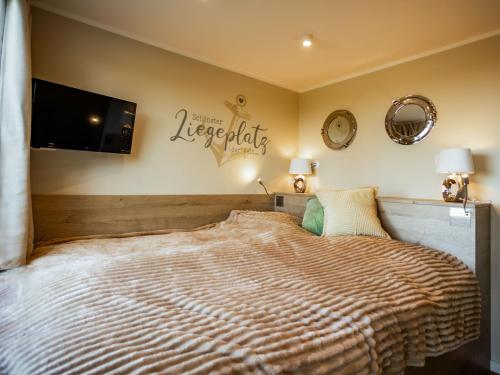 a bedroom with a large bed and a flat screen tv at Tiny Haus Schwalbe in Groß Kordshagen