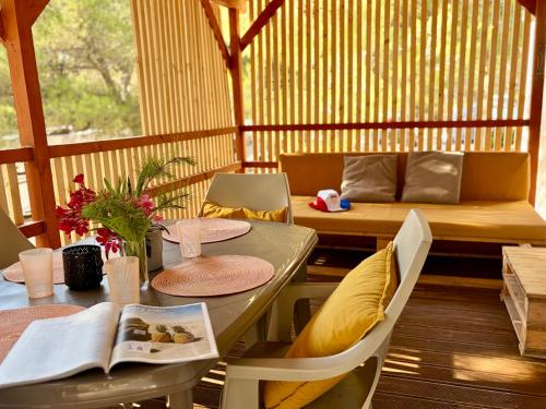 a porch with a table and chairs and a bench at Mobilehome Adams Glamping - Camp Adriatic in Primošten