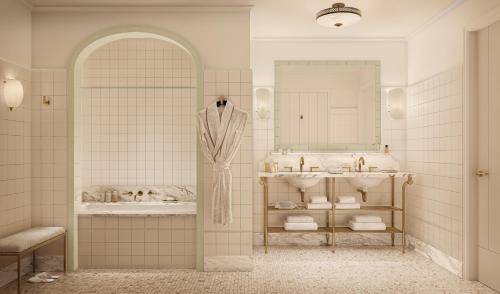 a bathroom with two sinks and a mirror at The Nora Hotel in West Palm Beach