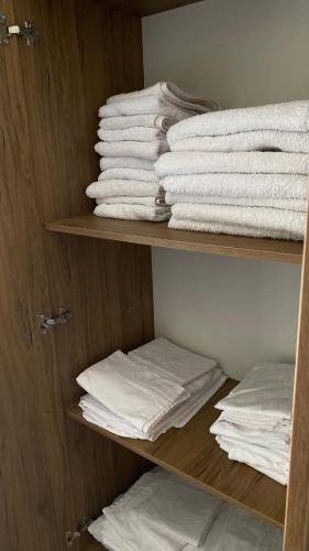 a group of towels on a shelf in a closet at Duki's Apartments in Orikum