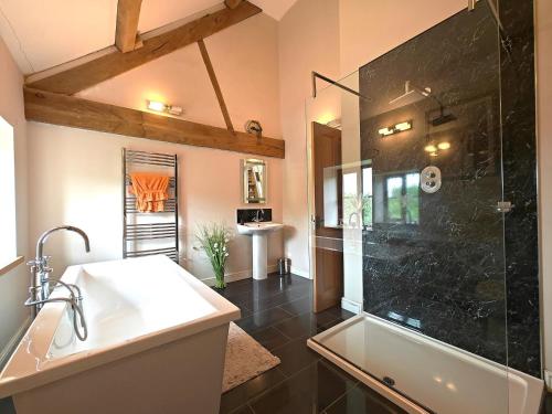 a bathroom with a shower and a sink and a tub at 5 Bed in Garth oc-c44957 in Garth