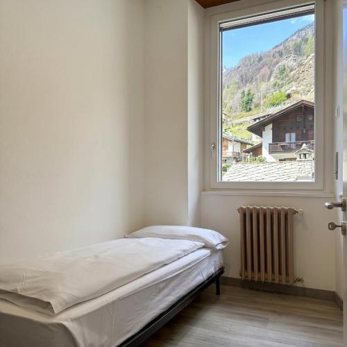 a bedroom with a bed and a window at La Terrazza di Gino in Grosio