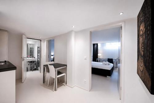 a white room with a bed and a desk and a table at VISIONAPARTMENTS Binzmühlestrasse 50 - self check-in in Zurich