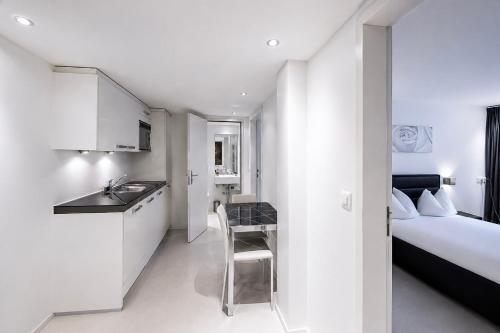 a room with a kitchen and a bedroom with a bed at VISIONAPARTMENTS Binzmühlestrasse 50 - self check-in in Zurich