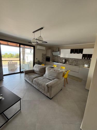 ein großes Wohnzimmer mit Sofa und Küche in der Unterkunft Villa ManuCamp in Reggio di Calabria