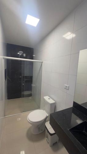 a bathroom with a toilet and a glass shower at Chimarrão Hotel in Juazeiro