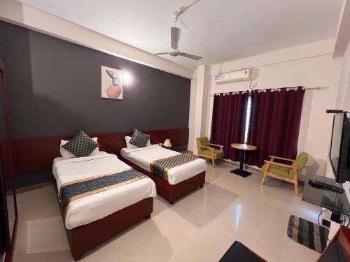 a hotel room with two beds and a tv at Peace Residency in Jāmb