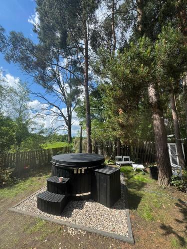 a picnic table in a yard next to a tree at Babi Domek - Leśny dom z balią in Kruczy Borek