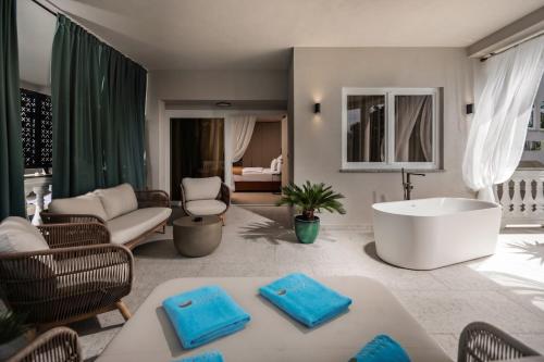 a bathroom with a tub and a living room at Hotel Malin in Malinska