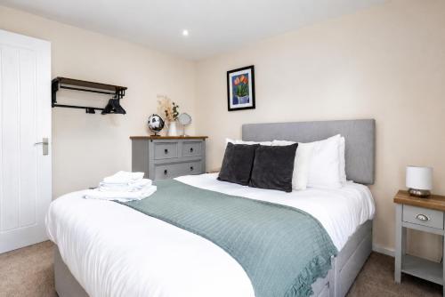 a bedroom with a large bed with white and blue sheets at COTTON HOUSE - Peak District Escape, Walks, Canal & Cromford Mill in Matlock