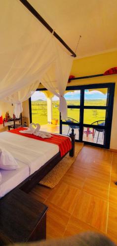 a bedroom with a bed with a large window at Narasha homestay in Talek