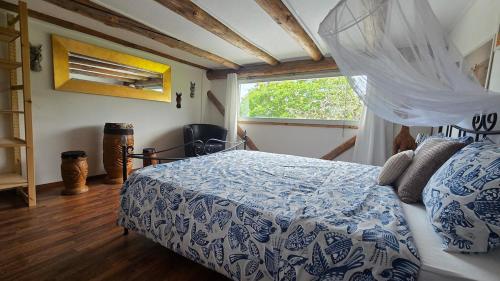 a bedroom with a blue and white bed and a window at Mutzgraben Lodge in Seeberg