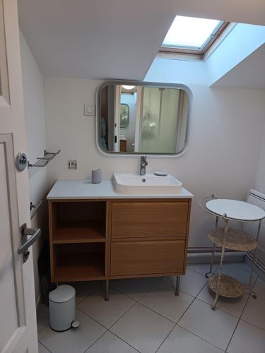 a bathroom with a sink and a mirror at Le Cottage in Marçon