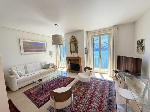 a living room with a couch and a fireplace at Cristoforis Lake View House in Carate Urio
