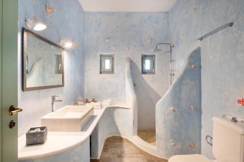 a bathroom with a white sink and a blue wall at Villa Fotis in Ano Syros