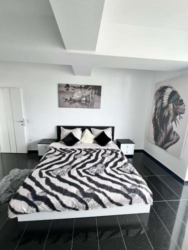 a zebra print bed in a white bedroom at Rania Penthouse 2 in Şelimbăr