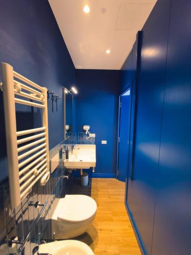 a blue bathroom with a toilet and a sink at Dimora Coloré in Nereto