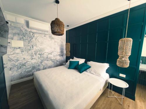 a bedroom with a white bed and a green wall at Dimora Coloré in Nereto