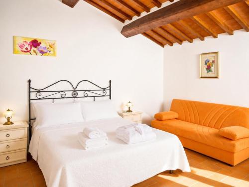 a bedroom with a bed and a orange couch at Casale Donatelli in Radicofani