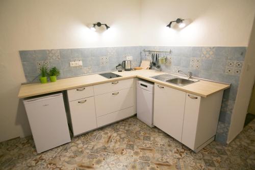 a kitchen with white cabinets and a sink at Heldův pokojík v centru města in Zákupy