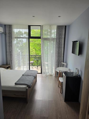 a bedroom with a bed and a large window at French Hotel in Kobuleti