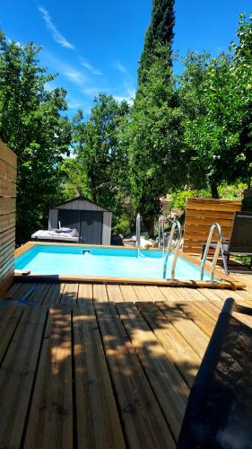 a large swimming pool with a wooden deck at Entre Terrasses et Restanque - Pierrevert in Pierrevert