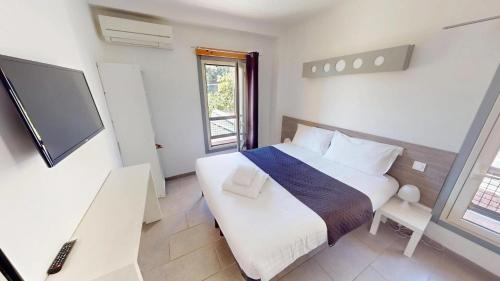 a bedroom with a bed and a flat screen tv at HÔTEL Relais de Monti in Menton