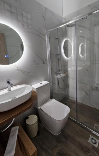 a bathroom with a toilet and a sink and a shower at Chilies Rizes in Nafpaktos