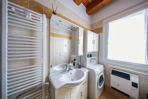 a bathroom with a sink and a washing machine at B&B We CaRe Appartamento in Lendinara